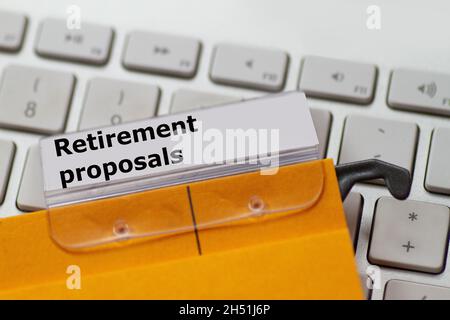 a label with the words: Retirement proposals on a hanging folder on a computer keyboard Stock Photo