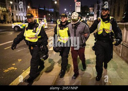 London, UK. 05th Nov, 2021. A protester is detained by police and led away during the annual Million Mask march through the city. The Anonymous movement stands in solidarity for a society which is marginalised by the political elite and associated corporations. Credit: Andy Barton/Alamy Live News Stock Photo