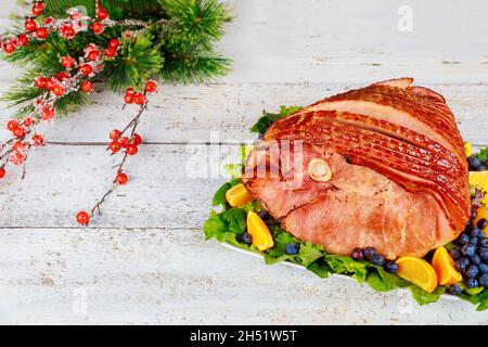 Whole pork ham with fresh fruits. Holiday Christmas meal. Stock Photo