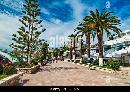 Saranda, Albania - September 2016: Palm trees, tourists on the promenade in the resort town of Saranda, Albania. The southernmost city of Albania, a r Stock Photo