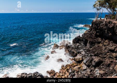 Waves Crashing Against The Rugged Volcanic Sea Cliffs of MacKenzie State Recreation Area, Hawaii Island, Hawaii, USA Stock Photo