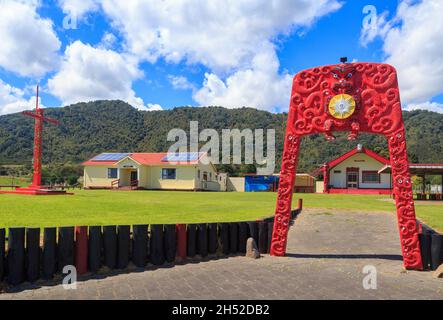 Otuwhare Marae, a Maori meeting place in the remote village of Omaio, New Zealand. A colorful archway with Maori carvings sits at the entrance Stock Photo
