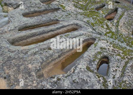 Anthropomorphic tombs carved out of sandstone. Around the church of San Adrian martyr, dating from the high medieval era. Regumiel de la Sierra Burgos Stock Photo