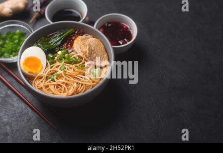 Ramen is japanese noodles in a bowl with meat and vegetables or seafood, often flavored with soy sauce or miso, with toppings such as sliced pork Stock Photo