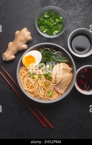 Ramen is asian noodles in a bowl with meat and broth, often flavored with soy sauce or miso, with toppings such as sliced pork, nori, menma Stock Photo