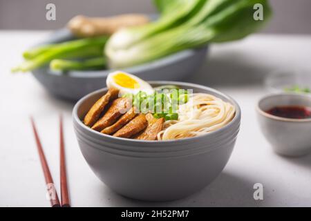 Ramen is asian noodles in a bowl with meat and vegetables or seafood, often flavored with soy sauce or miso, with toppings such as sliced pork, nori, Stock Photo