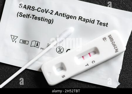 Positive Covid-19 antigen test kit, one step coronavirus antigen rapid test, saliva swab, 1 test box with imagine of lungs, close up Stock Photo