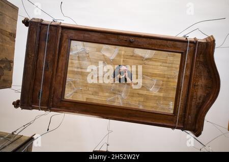 photographer in a mirror of a furniture above him Stock Photo