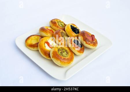 Various tiny delicious mini pizza on a white plate, isolated on white background Stock Photo