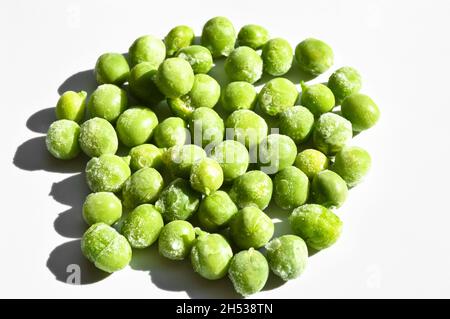 Fresh green frozen peas and grains, nutritious and healthy green vegetables, isolated on white background Stock Photo