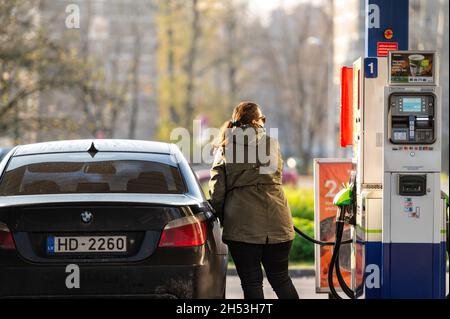 Riga, Latvia, November 2, 2021: a woman refuels a car at a Neste unmanned petrol station Stock Photo