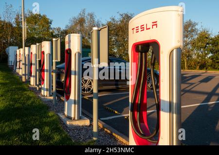 Tesla Supercharger station for charging electric cars vehicles at Telford Motorway Services, Shropshire, England, UK Stock Photo