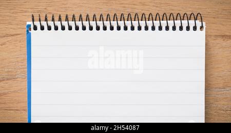Top of spiral bound notebook open on a wooden desk, flat lay ideal for background or template Stock Photo