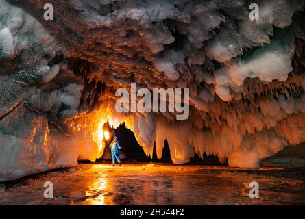 A girl with a  torch near icy grotto on Baikal Lake Stock Photo