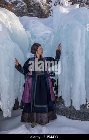 A Buryat girl standing on the icy cost on a little island on Baikal Lake in winter time Stock Photo