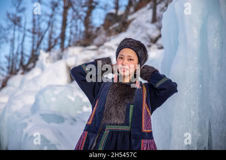 A Portrait of Buryat girl standing on the icy cost on a little island on Baikal Lake in winter time Stock Photo