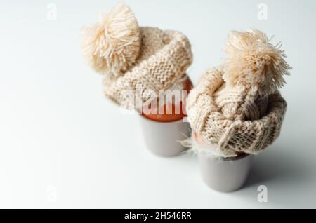 Fresh free range eggs with natural feathers in egg cups, eggs in woolen caps, funny food Stock Photo