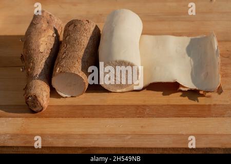 Cassava being peeled on a cooking board Stock Photo