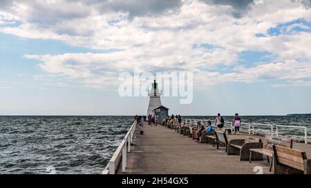 Port Dover, Canada-August 3, 2021: People visiting heritage lighthouse in Port Dover  West Pier on Lake Erie, Ontario, Canada. Stock Photo