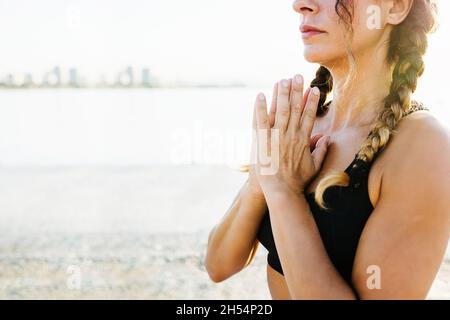 Woman meditating in sukhasana pose by the sea Stock Photo