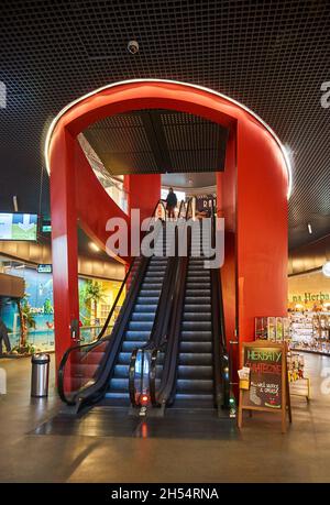 POZNAN, POLAND - Nov 26, 2017: An escalator with female on the top in the Kupiec Poznanski shopping mall Stock Photo