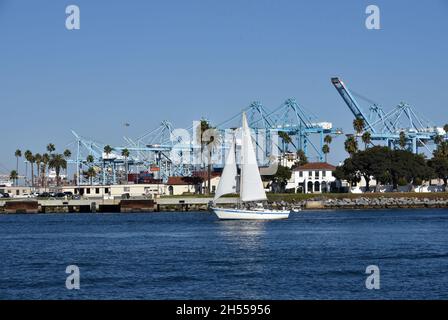 Los Angeles, CA USA - October 15, 2021: Sailboat passing the shipping containers and gantry cranes in the main channel of the Port of Los Angeles on a Stock Photo