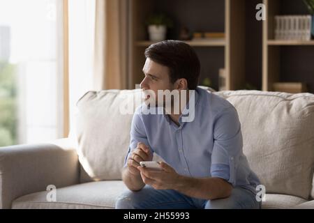 Happy young man using cellphone at home. Stock Photo