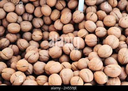 Heap of fresh walnuts displayed on the counter at the farmers market. Close up view. Stock Photo