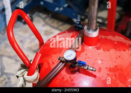 Pneumatic engine oil extractor or waste oil drainer machine in a car repair shop. Stock Photo