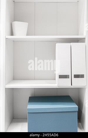 A minimalist wardrobe, half-empty shelves in a white wardrobe. Stock Photo