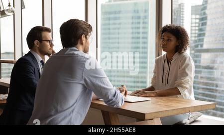 Focused male employers interviewing african american candidate. Stock Photo