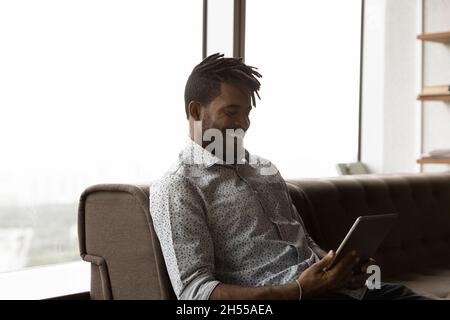 Happy young african american man using digital tablet. Stock Photo