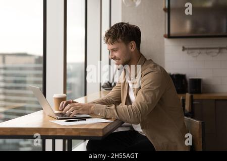 Happy young caucasian man working on computer. Stock Photo