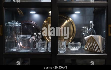 Beautiful vintage tableware in a sideboard behind glass. Stock Photo
