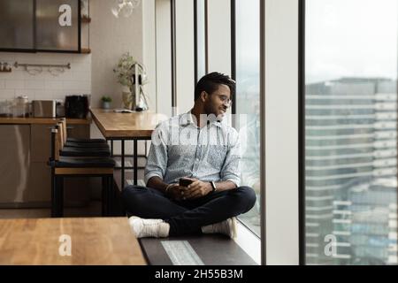 Relaxed carefree african american man contemplating cityscape view. Stock Photo