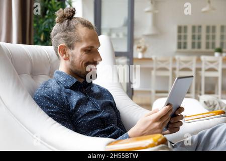 Happy young hipster man using digital touchpad gadget. Stock Photo