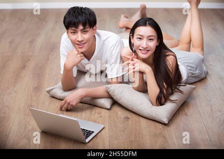 Young couple lying on the floor and using a digital tablet Stock Photo