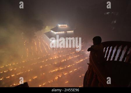 NOVMBER 06,2021,DHAKA,BANGLADESH-Thousands of Hindu devotees sit with Prodip and pray to God in front of Shri Shri Lokanath Brahmachari Ashram temple during the religious festival Kartik Brati, also known as Rakher Upobash in Dhaka, Bangladesh. Every year thousands of Hindu devotees gather in front of Shri Shri Lokenath Brahmachari Ashram temple for the Kartik Brati or Rakher Upobash religious festival in Barodi, Near Dhaka, Bangladesh. Devotees sit in front of candles light (named locally as Prodip). Lokenath Brahmachari who is called Baba Lokenath was an 18th Century Hindu saint and philosop Stock Photo