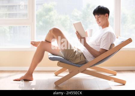 Young man reading at home Stock Photo