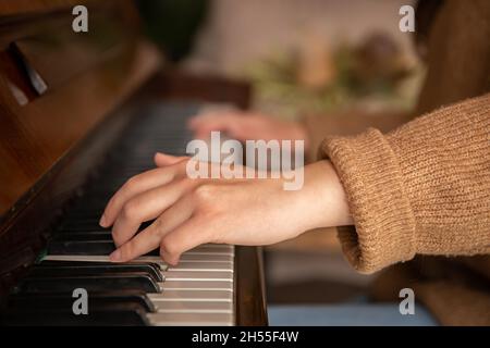 Close-up of female hands playing the piano. Stock Photo