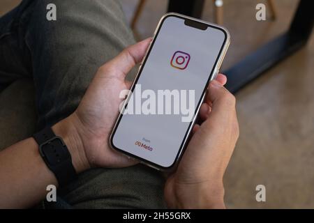 CHIANG MAI, THAILAND - NOV 07, 2021: A man hand holding iphone with logo of instagram from meta. Instagram reels for making short videos and story Stock Photo