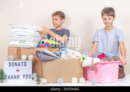Christmas donation to animal shelter. Volunteer teenagers collecting donations, preparing animal donation box for animal shelters at Christmas charity Stock Photo