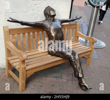 Life-size bronze sculpture depicting Baetle John Lennon sitting on a bench by Lawrence Holofcener in Carnaby Street, London, UK Stock Photo