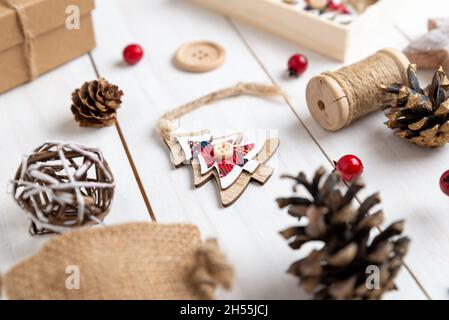 Wooden Christmas tree ornament with twine and button decoration surrounded by rustic Christmas decorations Stock Photo