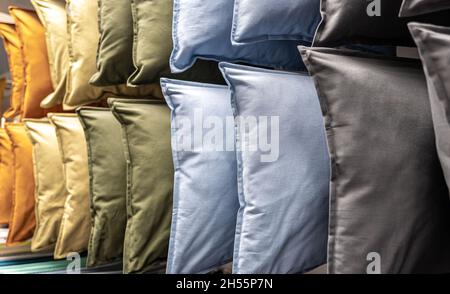 Textile pillows of different colors on the counter in the store. Stock Photo
