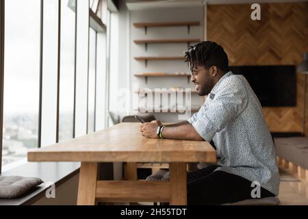 Happy millennial african american man using smartphone. Stock Photo