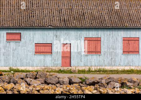 Wooden house painted in light blue, red doors and shutters. Cayeux-sur-Mer, Opal Coast, France Stock Photo