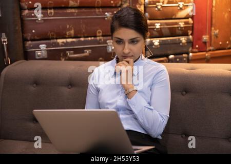 Focused thoughtful young indian businesswoman working on computer. Stock Photo