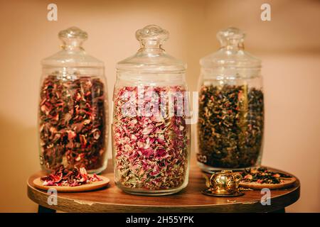 Three glass containers full of different sort of dried tea leaves with different colours Stock Photo