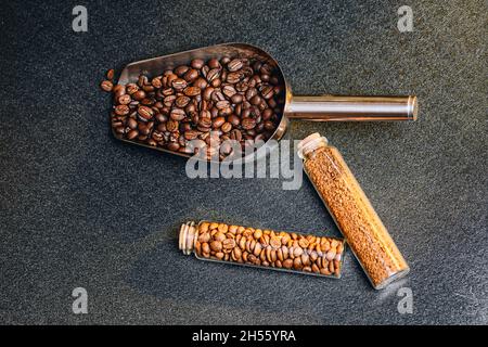 Top view of metal scoop and mini glass bottles full of different types of coffee beans Stock Photo